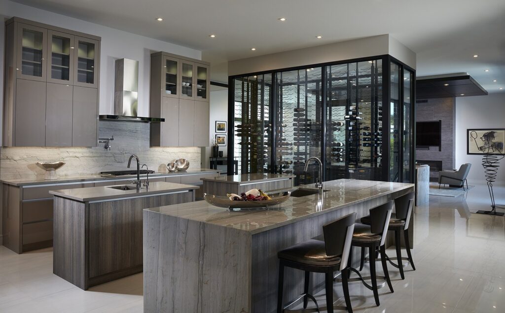Kitchen with stone islands and a glass-enclosed wine display at Scott Residence