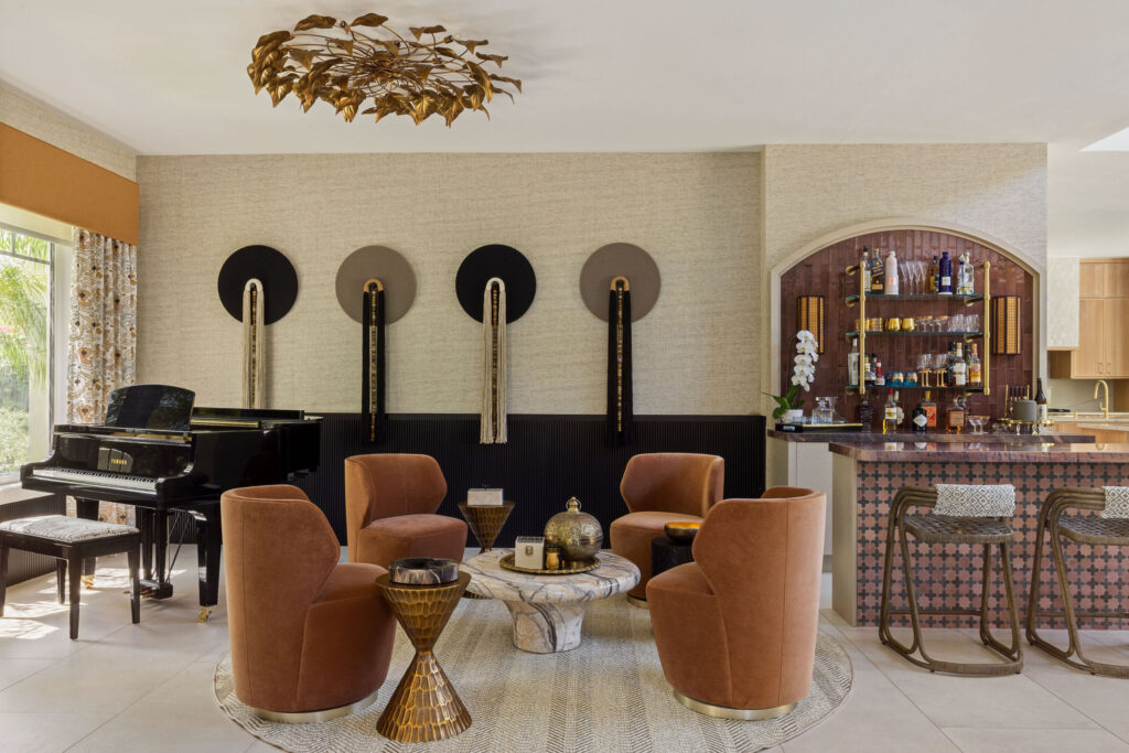 Wolfe Residence lounge with rust-colored chairs, a piano and a curved bar